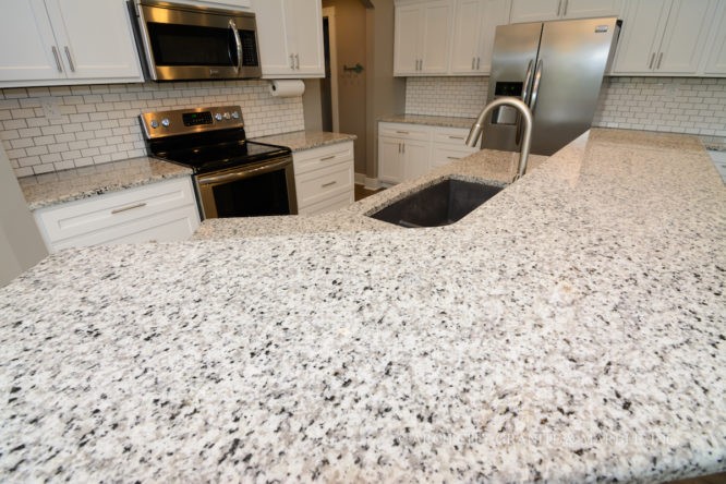 All white kitchen with Luna Pearl granite, white cabinets, and white subway tile backsplash in union, mo