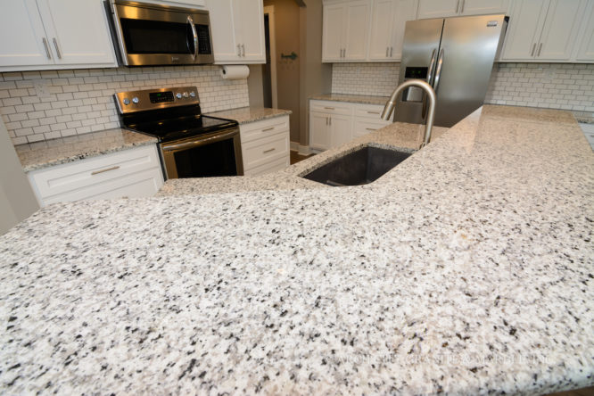 All white kitchen with Luna Pearl granite, white cabinets, and white subway tile backsplash in union, mo