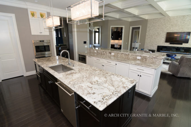 White granite counters installed in a kitchen with two islands of white and dark colored cabinetry in illinois area